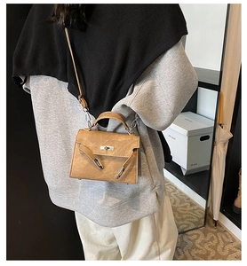 Sac à main classique camel avec boucle métallique porté par un mannequin