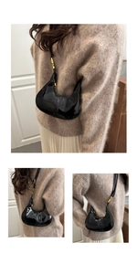 Detail of glossy black patent leather hobo bag with adjustable gold buckle and sleek texture