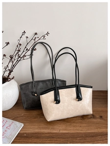 Detailed view of retro tote bags in grey and beige with metal buckles and knot accents