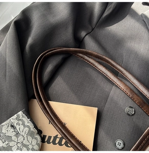 Detail of dark grey twill fabric texture with buttons and delicate white lace cuff splicing