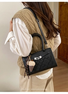 Détail du sac à main rétro noir gaufré avec motif feuilles et breloque crème glacée
