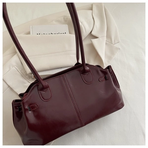 Detail of burgundy leather tote bag with pleated texture and stylish double handles