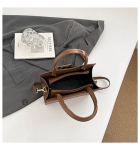 Detailed interior of a brown leather tote bag with zip compartment and textile lining