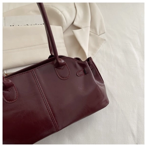Detail of the stitching and smooth wine red leather texture of this elegant handbag