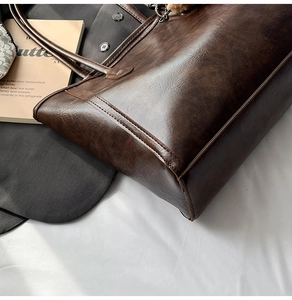 Detailed close-up showing texture and stitching of a vintage dark brown tote bag