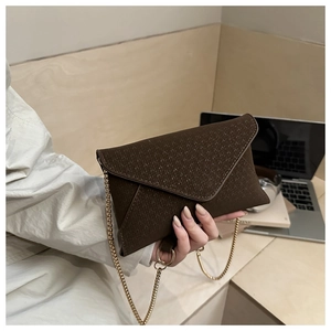 Close-up of a dark brown envelope chain bag with fine geometric embossed texture