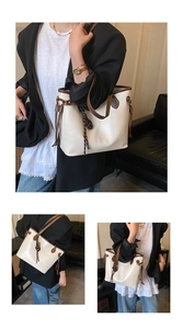 Detail of vintage contrast tote bag in cream PU leather with brown trim and woven charm