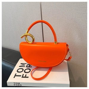 Détail du sac à main orange demi-lune avec poignée dorée artistique et bandoulière fine