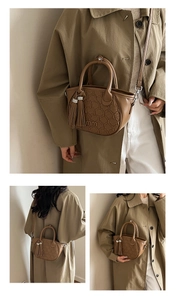 Detail view of brown quilted leather tote bag with tassels and elegant metal hardware