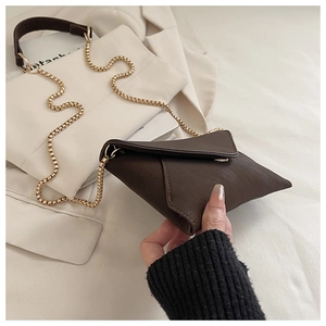 Detailed close-up of brown vintage envelope bag with smooth leather and gold chain strap