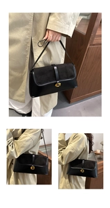Detail view of black paneled baguette bag featuring a golden G-logo magnetic buckle