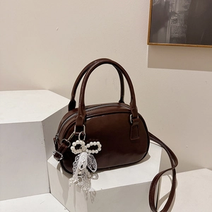 Sac croissant marron chocolat avec pendentif nœud en perles sur socles blancs