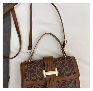 Détail du sac à bandoulière monogramme marron foncé avec boucle métallique dorée et poignée