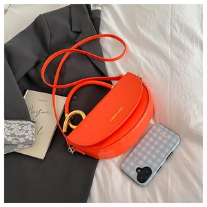 Détail du sac demi-lune orange avec poignée dorée et logo imprimé doré