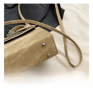 Gros plan sur la texture en toile et les clous de protection argentés du sac bandoulière