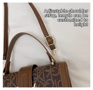Détail de la bandoulière en cuir réglable avec fermoir mousqueton doré sur le sac