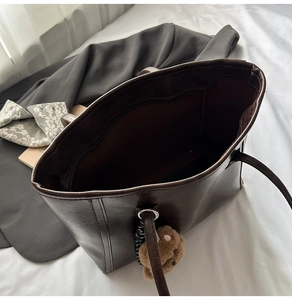 Top view of large capacity dark brown tote bag with plush bear charm and zip pocket