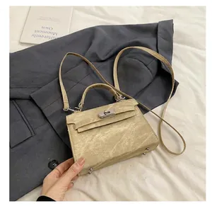 Détail du sac trapèze abricot avec fermoir rotatif en métal et texture en cuir finement grainé