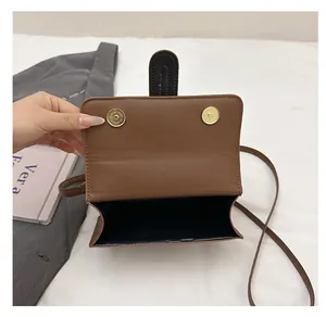 Vue de dessus d'un petit sac bandoulière en cuir marron avec double fermeture aimantée