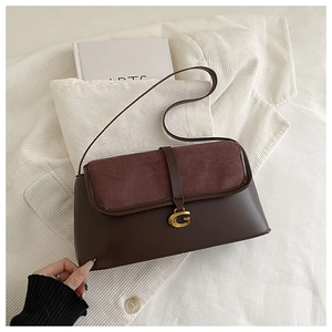 Detail of burgundy suede and brown leather flap bag with gold G-shaped buckle closure
