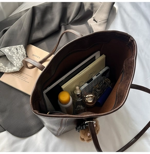 Interior view showing large capacity for tablet, books, and cosmetics in a brown tote