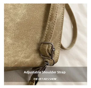 Détail de la bandoulière réglable en toile kaki avec boucle et crochet en métal argenté