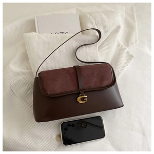 Detail view of the retro leather shoulder bag with gold G-logo and suede flap textures