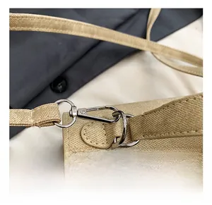 Vue macro détaillée des crochets en métal argenté et du tissu kaki sur un sac à bandoulière
