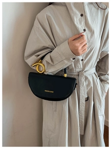 Détail du sac croissant en cuir noir avec poignée ronde unique en métal doré