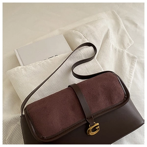 Detail of retro dark brown shoulder bag with suede flap and gold G-shaped buckle