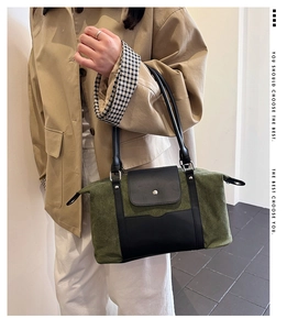 Olive green canvas and black leather shoulder bag styled with a beige trench coat