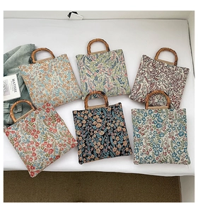 Detail view of colorful floral tote bags featuring vintage-style bamboo handles