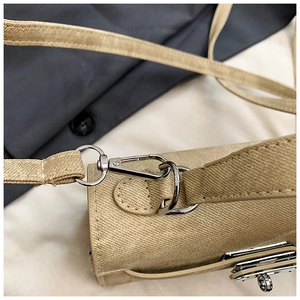 Gros plan du crochet métallique argenté et du connecteur sur le sac en toile beige