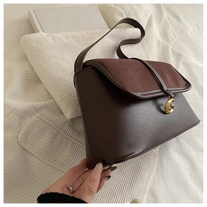 Detail view of smooth chocolate faux leather shoulder bag with golden G-buckle closure