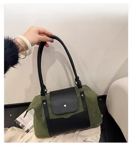 Detail of olive green suede and black leather paneling with magnetic metal buckle
