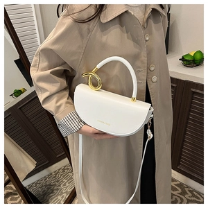 Détail du sac selle blanc avec poignée en métal doré et lettrage fashion élégant