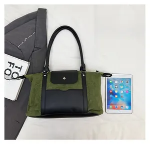 Detail view of large green travel tote bag showing capacity compared to a tablet and essentials