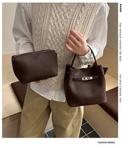Detail of a brown lychee pattern leather bucket bag with a matching zipper pouch