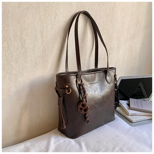 Detail of dark brown leather tote bag with unique pretzel charm and drawstring accent