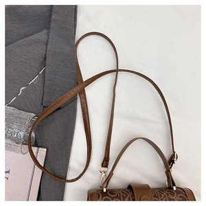 Gros plan sur un sac à bandoulière marron avec motif monogramme et boucle en métal