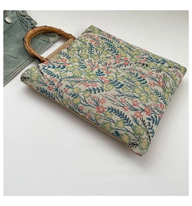 Detail of floral tapestry tote bag featuring vintage fabric and natural bamboo handles