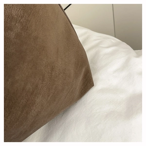 Close-up of the dark brown suede leather texture and stitching detail on the tote bag