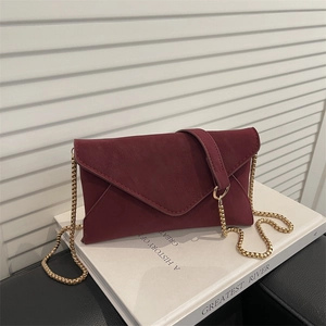 Elegant burgundy suede envelope bag with golden chain strap for shoulder and crossbody wear