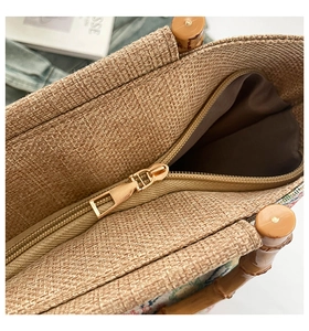 Close-up of woven tote bag with bamboo handles, colorful patterns and gold zipper closure