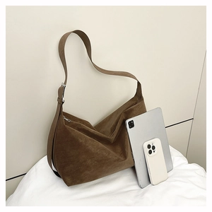 Brown suede hobo bag shown with tablet to demonstrate large storage capacity