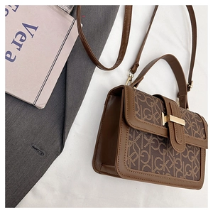 Détail du sac bandoulière marron à monogramme avec ferrures dorées et poignée