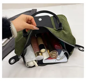 Spacious green felt handbag interior showing storage for tablet and cosmetics