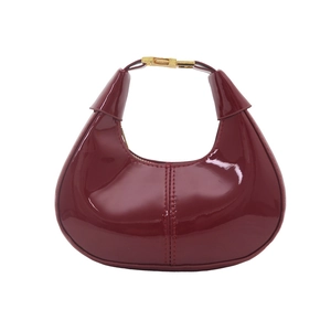 Sac croissant en cuir verni bordeaux brillant avec fermoir en métal doré élégant
