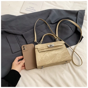 Détail du sac en cuir grainé beige avec fermoir argenté et comparaison de taille mini