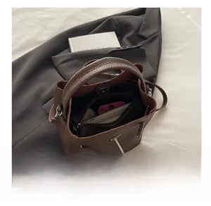 Spacious interior of brown pebbled leather bucket bag holding a phone and wallet